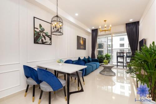 sala de estar con sofá azul, mesa y sillas en iHome Furnished Apartments with Free Gym & Pool, Airport Pick-Up Service, en Ho Chi Minh