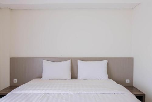 a bed with two white pillows in a room at Highest Value Studio Room at Annora Living Apartment By Travelio in Tangerang