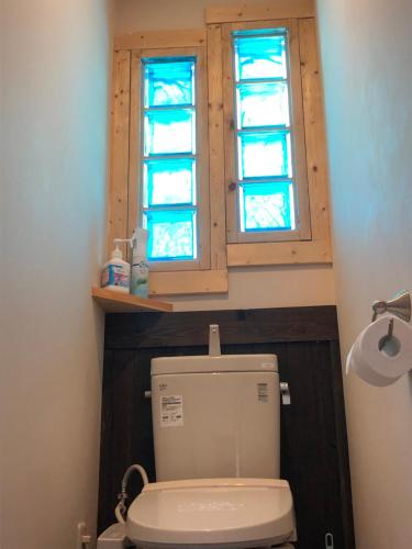 a bathroom with a toilet and a window at Ryder's House with Free use of 4W car in Hakuba
