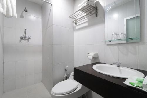 Dupak的住宿－Hotel Antariksa，白色的浴室设有卫生间和水槽。