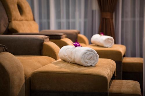 a row of brown chairs with white towels on them at Dora Cruise by HAG in Ha Long