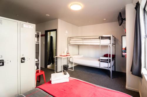 a room with two bunk beds and a red blanket at Urbanz in Christchurch