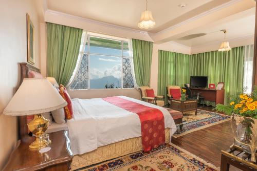 ein Hotelzimmer mit einem Bett und einem Fenster in der Unterkunft The Elgin Mount Pandim - Heritage Resort & Spa in Pelling