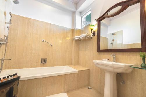 La salle de bains est pourvue d'un lavabo, d'une baignoire et de toilettes. dans l'établissement The Elgin Mount Pandim - Heritage Resort & Spa, à Pelling