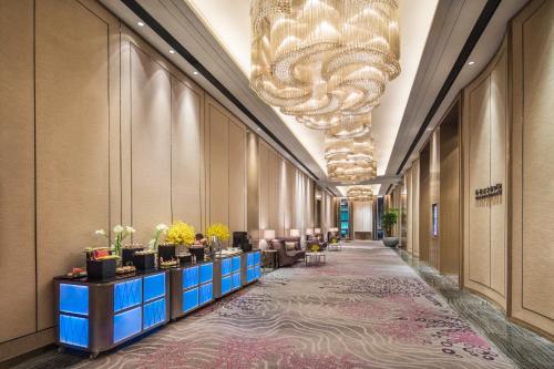 a lobby with a large chandelier and a long corridor at Crowne Plaza Harbin Songbei by IHG in Harbin
