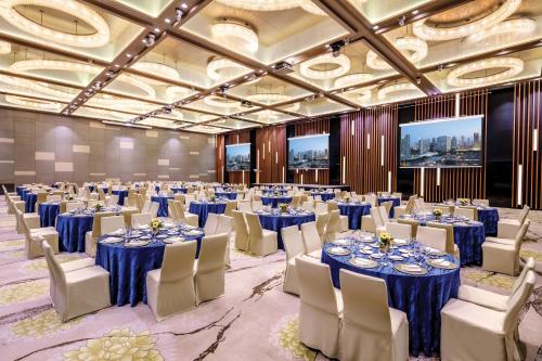a ballroom with tables and chairs in a room with blue tables and ceilings at PARKROYAL on Beach Road, Singapore in Singapore