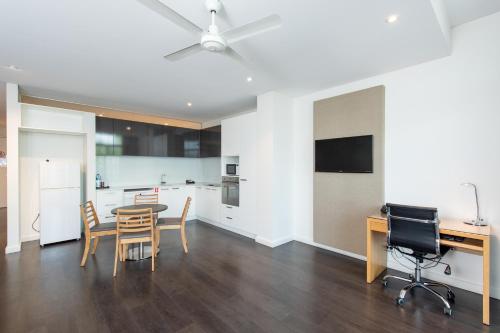 a kitchen and dining room with a table and chairs at Mawson Lakes Hotel in Adelaide