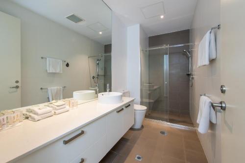 a bathroom with two sinks and a shower at Mawson Lakes Hotel in Adelaide