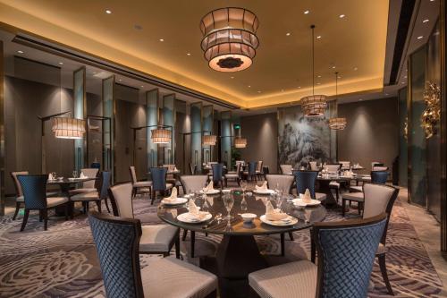 a restaurant with tables and chairs and chandeliers at Crowne Plaza Harbin Songbei by IHG in Harbin