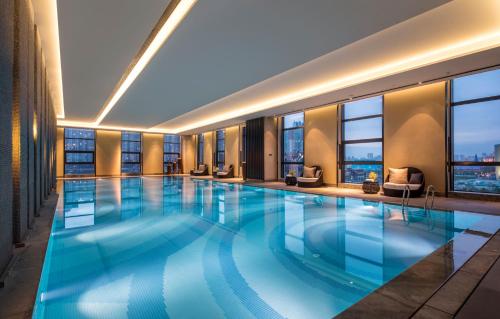 a large swimming pool in a hotel with windows at Crowne Plaza Harbin Songbei, an IHG Hotel in Harbin