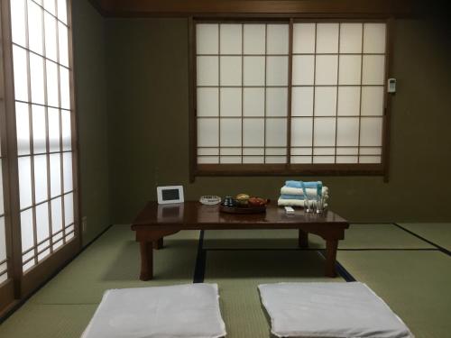 a room with a table and two white windows at Hamayuu in Higashiizu