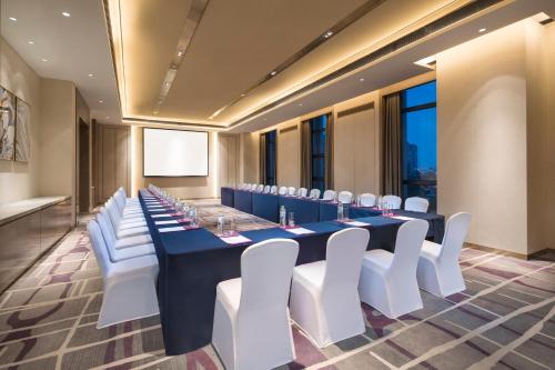 a conference room with a long table and white chairs at Crowne Plaza Harbin Songbei by IHG in Harbin