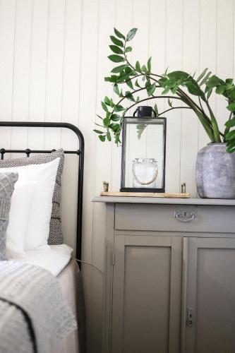 a bedroom with a bed and a plant on a dresser at Hapsal Dietrich apartemendid in Haapsalu