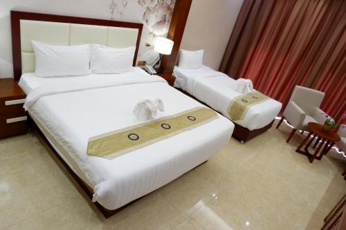 a hotel room with two beds with a tray on them at Paksong Danngarm Hotel in Paksong