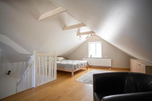 a attic room with a bed and a staircase at Silbernagel Apartment in Kuressaare