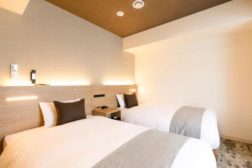 a hotel room with two beds in a room at Hotel Wing International Sapporo Susukino in Sapporo
