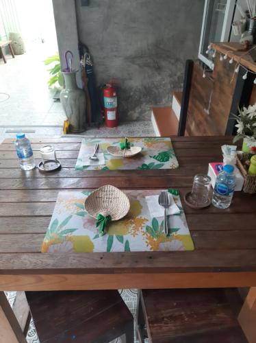 een houten tafel met twee borden eten erop bij Green Teak House in Bangkok