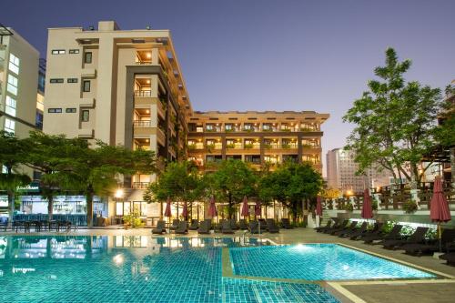 a swimming pool in front of a building at Areca Lodge in Pattaya