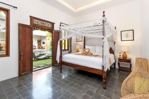sypialnia z łóżkiem z baldachimem i patio w obiekcie Bijia Villa 3BR w Private Pool - Peaceful Quiet Luxury Villa - Near Monkey Forest w mieście Ubud