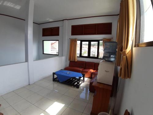 a living room with a couch and a tv at OYO Life 2884 Wisma Jatnika Syariah in Kuningan