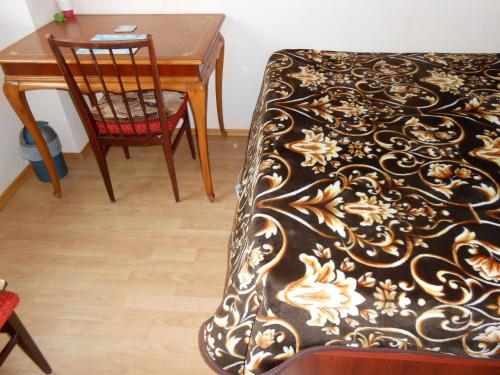 una mesa y una silla junto a una mesa con alfombra en Host Tina en Bucarest