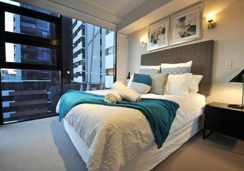 a bedroom with a large bed and a large window at Arena Convenient 2 Bedroom in Brisbane