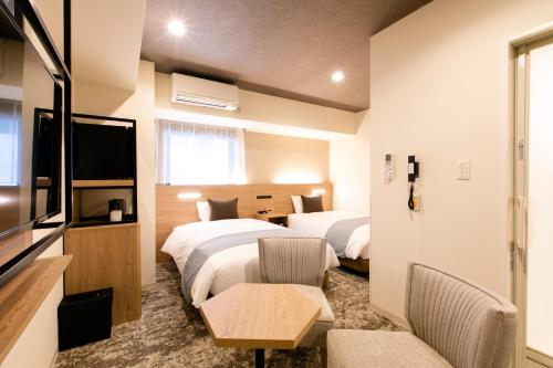 札幌市にあるホテル ウィングインターナショナル札幌 すすきののベッド2台とテレビが備わるホテルルームです。