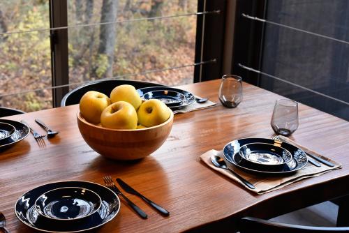 a wooden table with a bowl of pears on it at Shizuku Villas in Hakuba