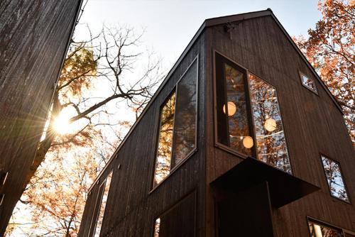 a timber clad house with windows on the side of it at Shizuku Villas in Hakuba