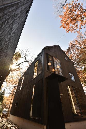a house clad in charred wood with a triangular facade at Shizuku Villas in Hakuba
