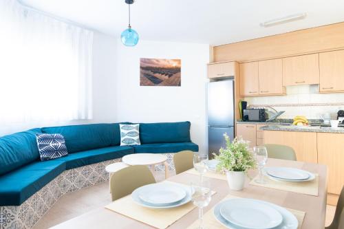 ein Wohnzimmer mit einem blauen Sofa und einem Tisch in der Unterkunft Villa Julia in Riumar