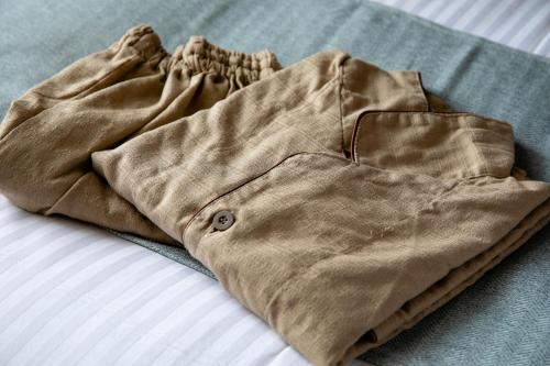 a pair of brown pants laying on a bed at Hotel Wing International Sapporo Susukino in Sapporo
