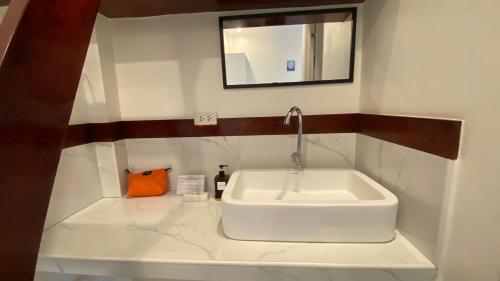 a white sink in a bathroom with a mirror at Villa del OZ Resort in Panglao Island