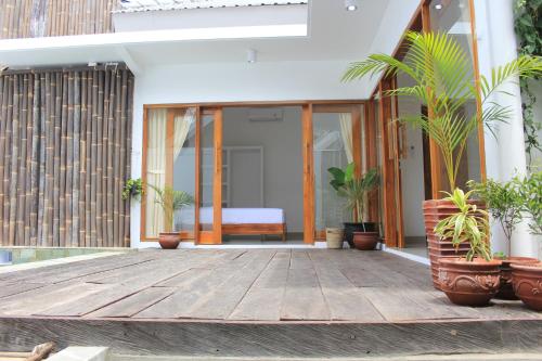 a wooden deck with potted plants on a house at Watukarung Prapto Homestay in Kalak