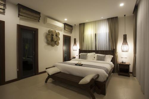 a bedroom with a large bed and pendant lights at Ozone Villa Phuket in Ban Pa Khlok