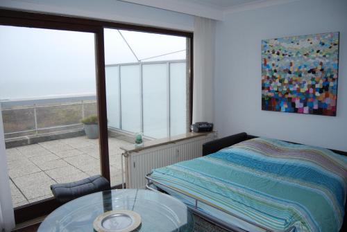 a bedroom with a bed and a glass table at Ruzettelaan 183 T11 bus 192 in Blankenberge