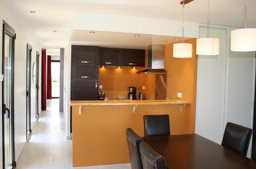 a kitchen and dining room with a table and chairs at Gites "Pieds dans L'Eau" ou "Plage" en FRONT DE MER à Asnelles , 3km d'Arromanches, 10km de Bayeux in Asnelles