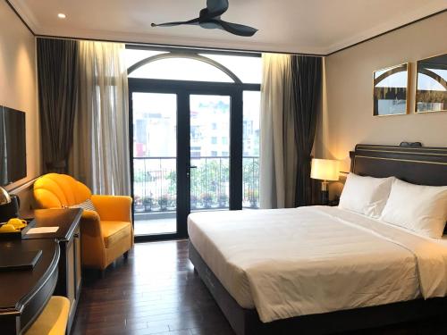 a hotel room with a bed and a chair at Hotel du Monde Art in Hanoi