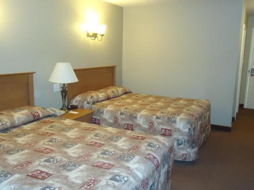 a hotel room with two beds and two lamps at Auberge Bouctouche Inn & Suites in Bouctouche