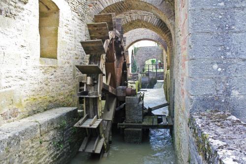 a canal in a castle with a bunch of wooden shelves at gîte de la Cabotte in Bussy-le-Grand