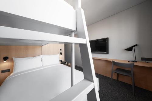 a bedroom with a bed and a desk and a tv at Nine Tree by Parnas Seoul Dongdaemun in Seoul