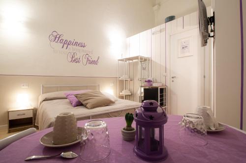 a bedroom with a bed and a table with a purple table cloth at B&B Patrizio in San Benedetto del Tronto