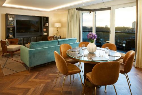 a living room with a couch and a table and chairs at Cheval Gloucester Park at Kensington in London