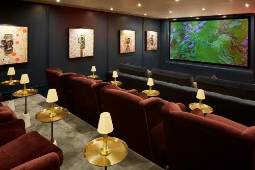 a waiting room with chairs and a flat screen tv at Cheval Gloucester Park at Kensington in London