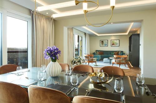a dining room with a table and chairs and a living room at Cheval Gloucester Park at Kensington in London