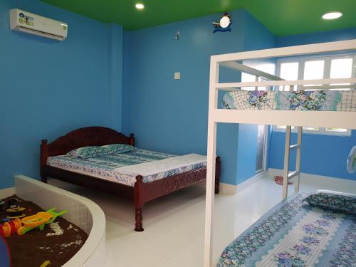 チャウドックにあるHOMESTAY VILLAの青い壁のベッドルームで、二段ベッド2組が備わります。