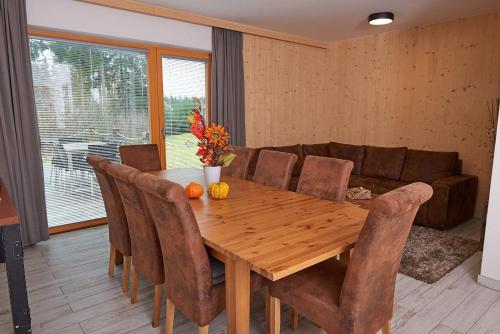 a dining room with a wooden table and chairs at HT Chalets Harrachov in Harrachov