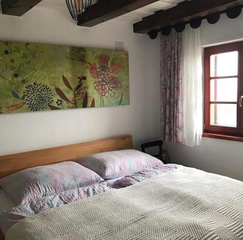 a bedroom with a bed and a painting on the wall at Kellerstöckl Knopf in Winten