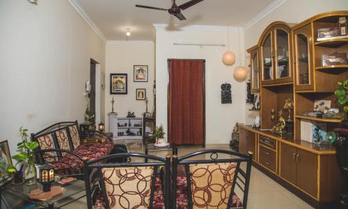 Homestay for Women في كويمباتور: غرفة معيشة مع كراسي ومروحة سقف