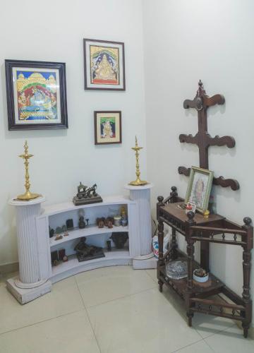 a room with a white wall with a cross and a table at Homestay for Women in Coimbatore
